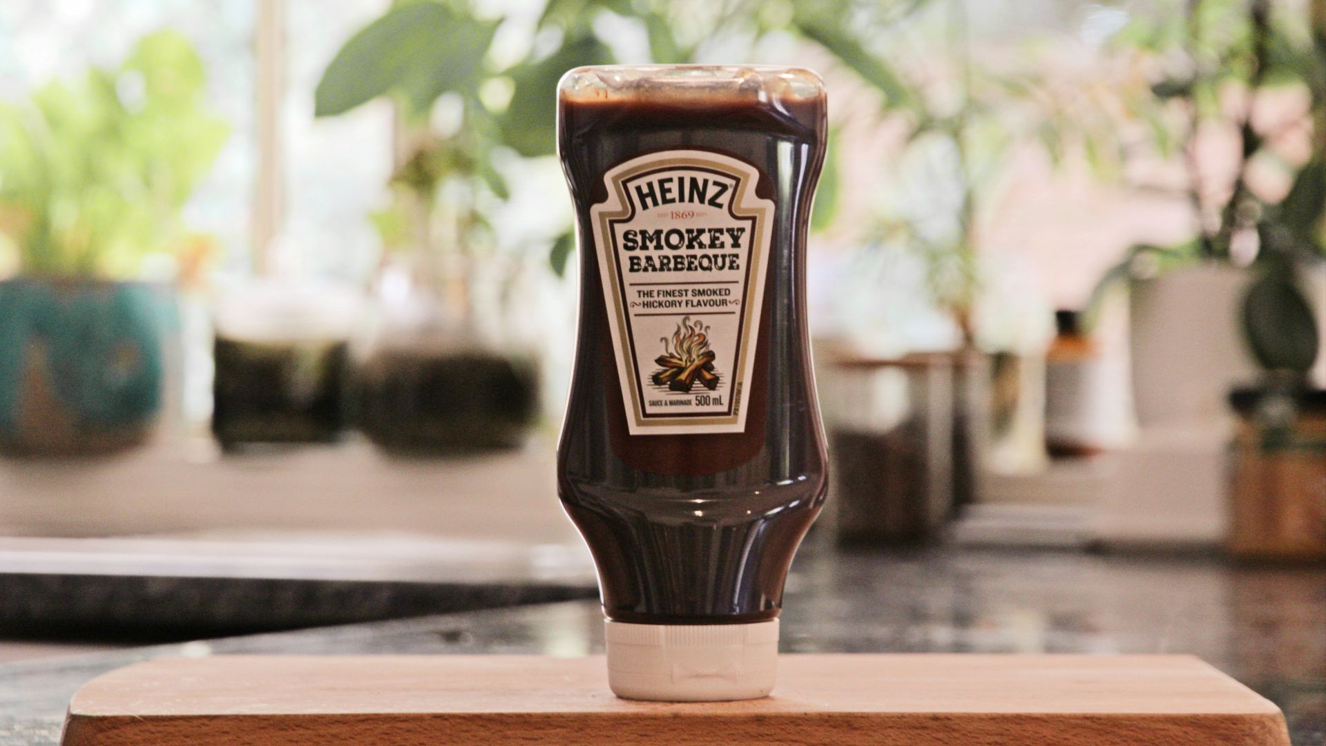 a bottle of ketchup sitting on top of a cutting board