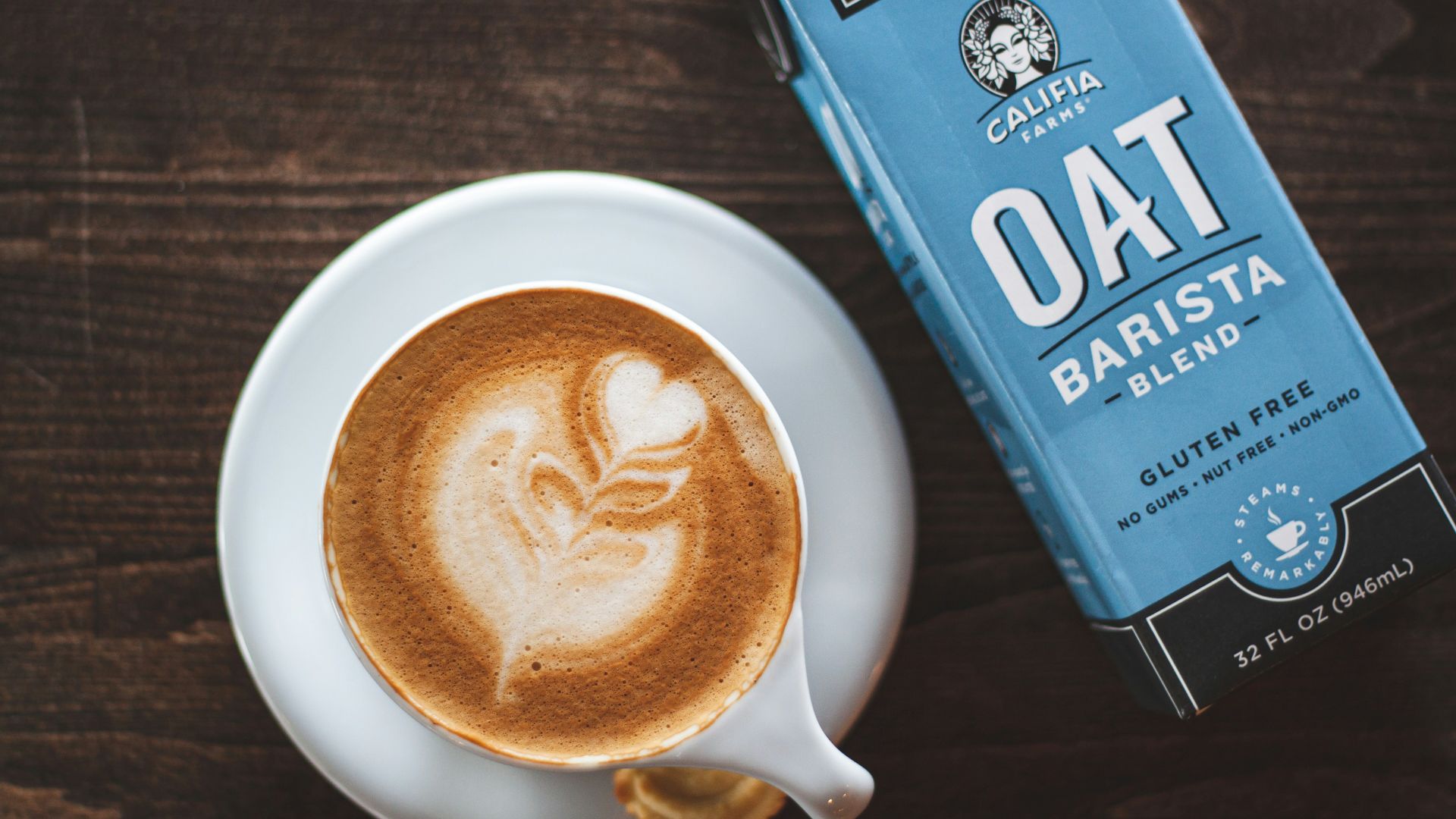 cup of latte beside oat barista box