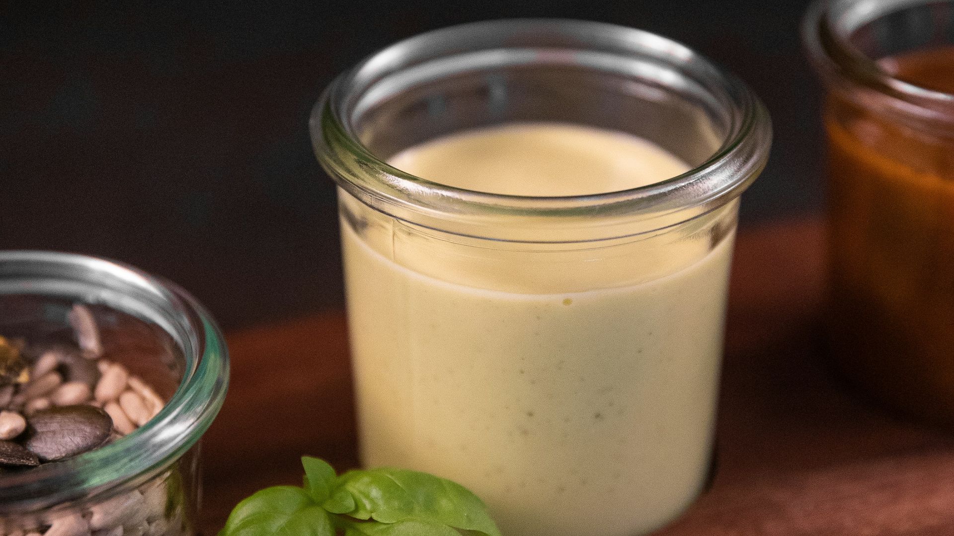a wooden cutting board topped with jars filled with food