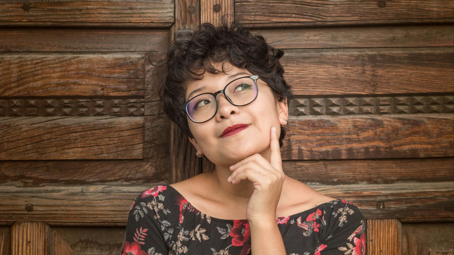 woman leaning against door while holding her cheek