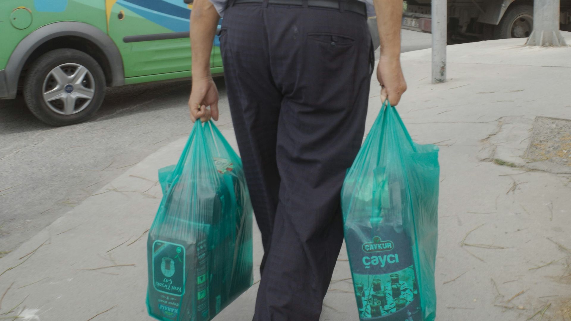 A man walking down the street carrying bags