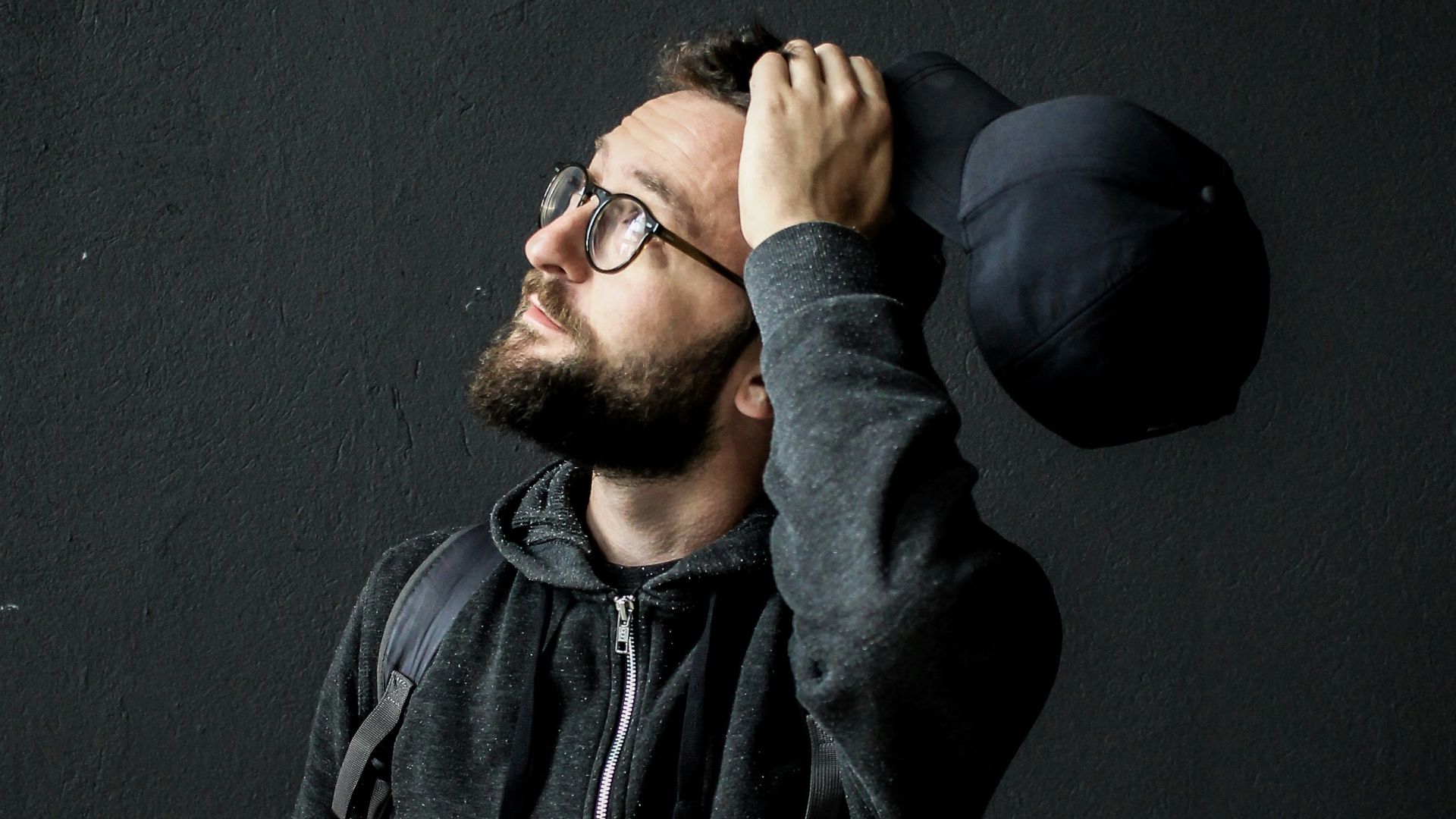 man looking up holding his hair
