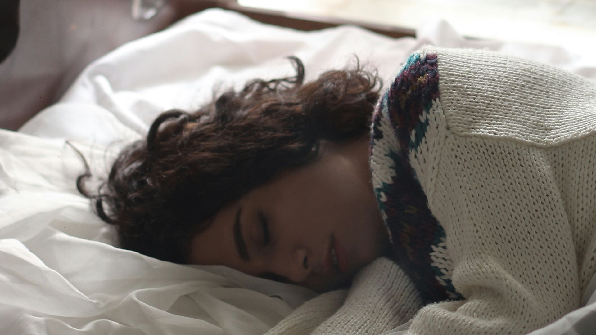 woman sleeping on bed beside book
