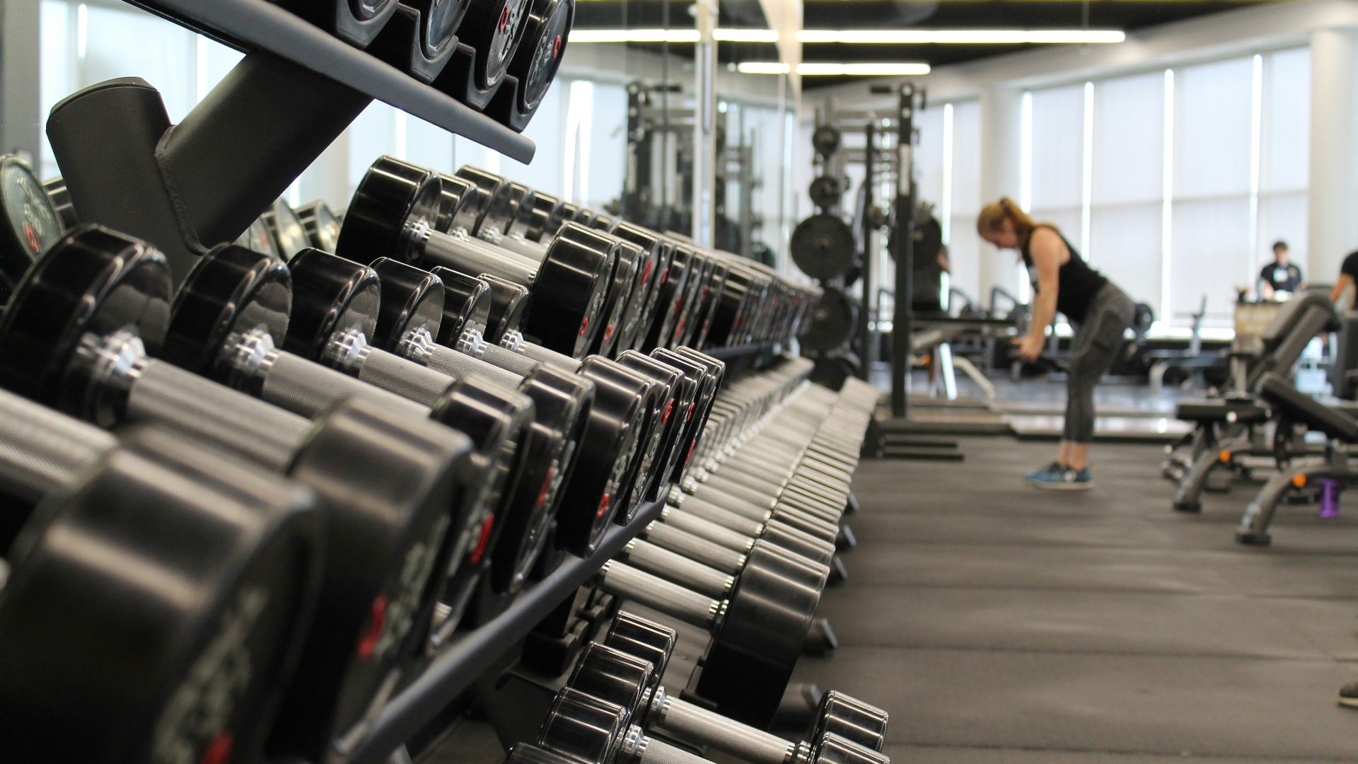 woman standing surrounded by exercise equipment