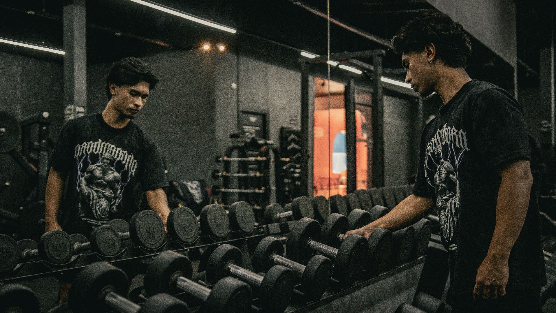 A couple of men standing next to each other in a gym