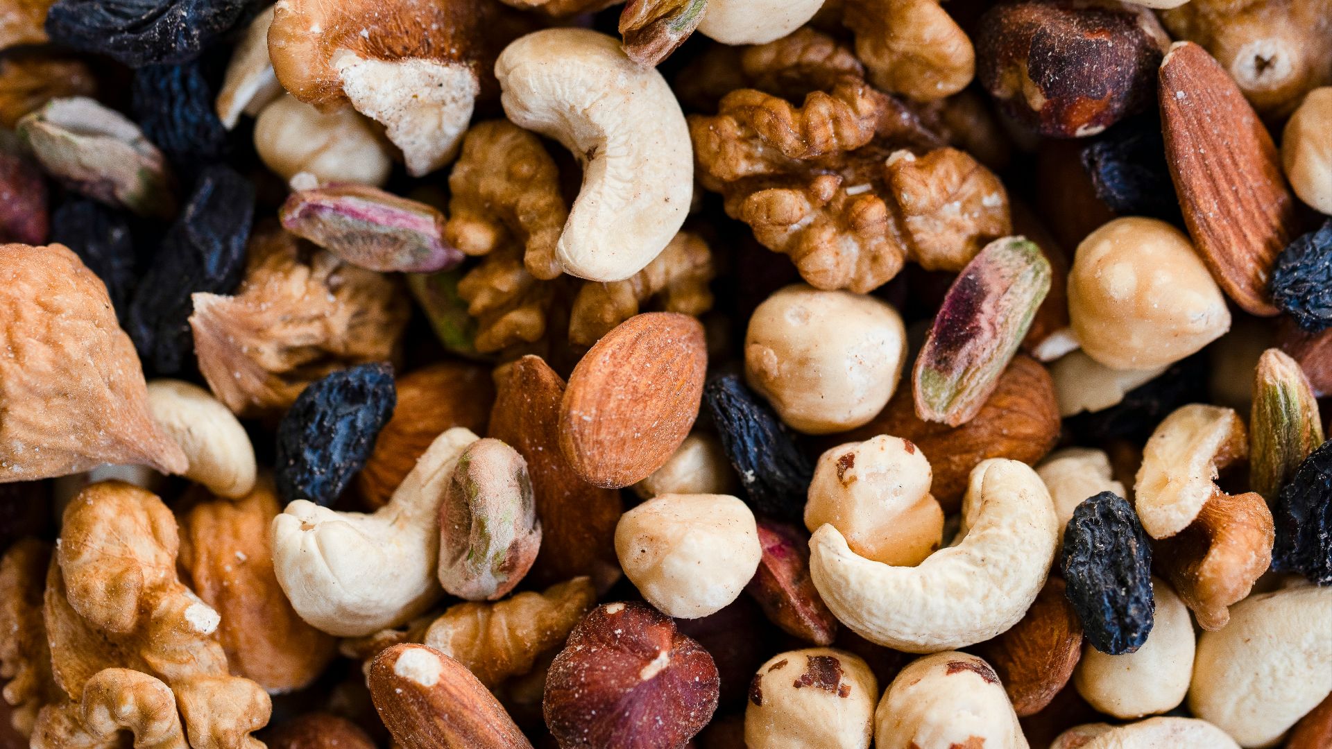 A close-up view of a mixed nut and raisin blend.