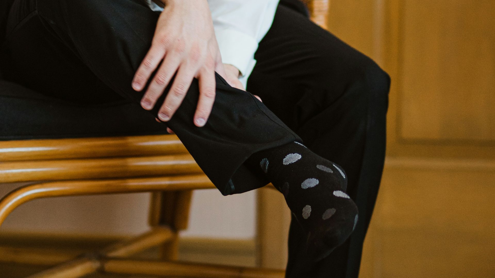 Man in white shirt, black pants, and polka dot socks