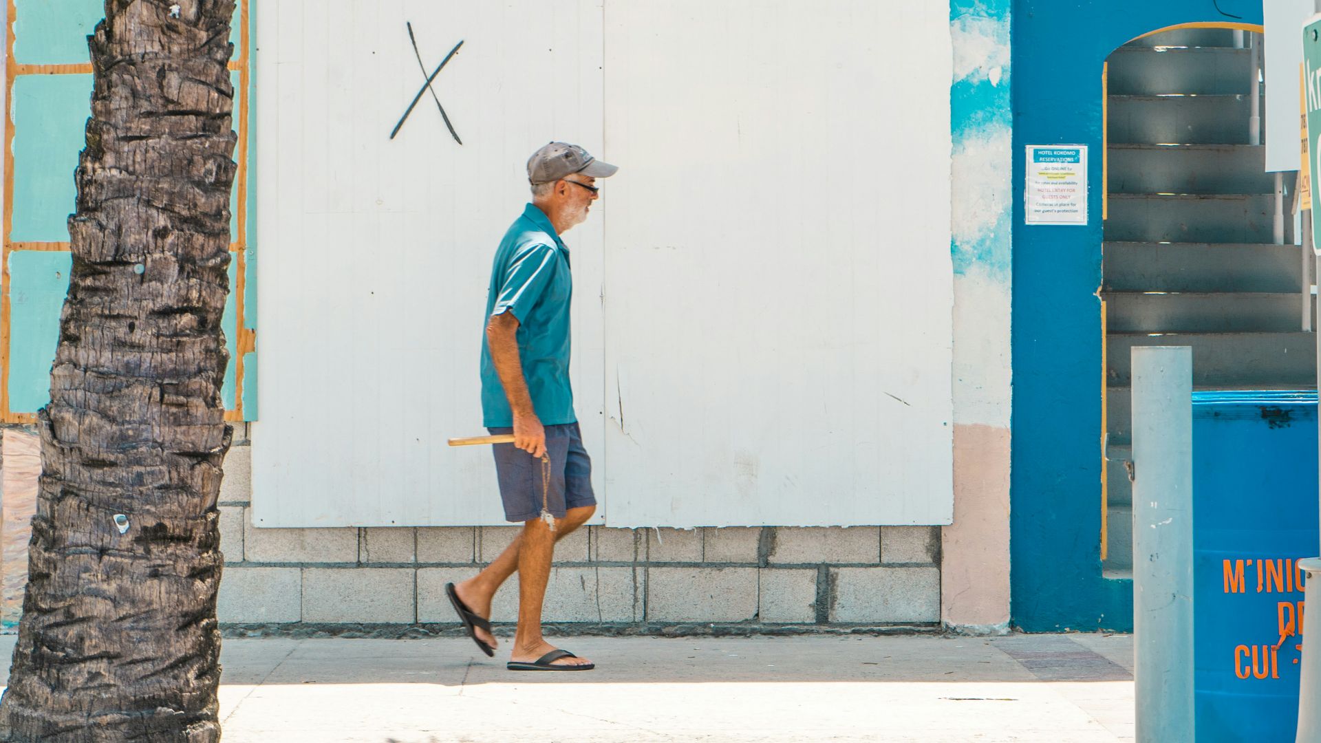 woman in blue t-shirt and blue shorts standing near blue and white wall during daytime