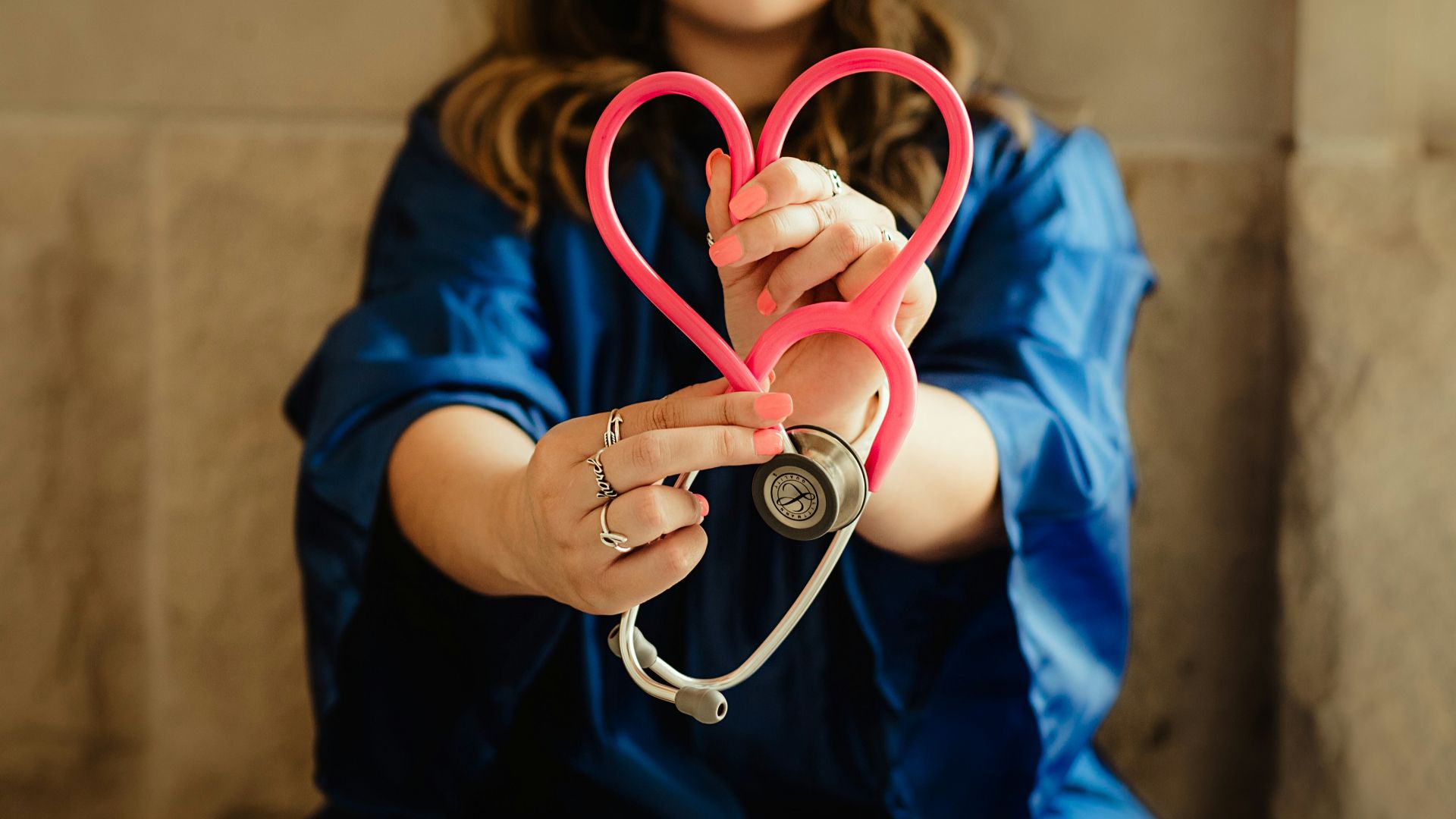 girl in blue jacket holding red and silver ring