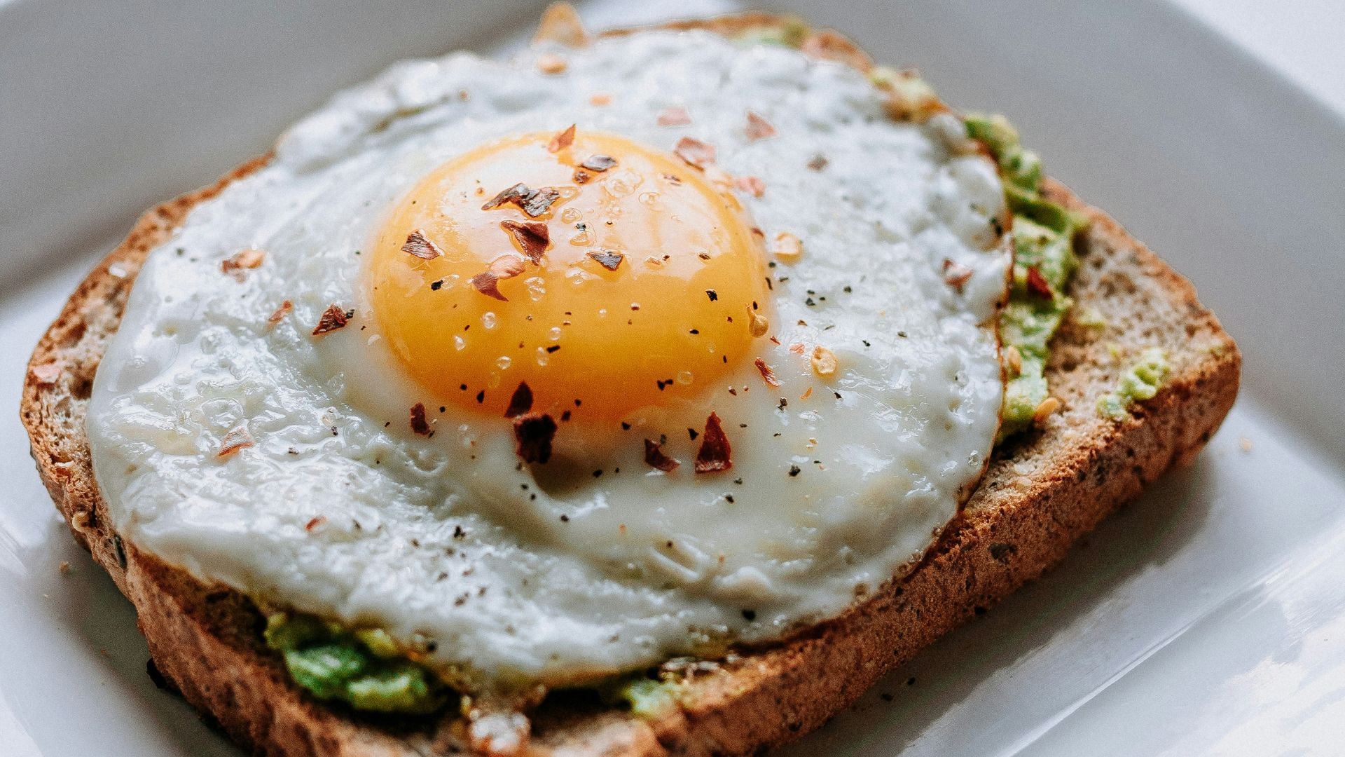 bread with sunny side-up egg served on white ceramic plate