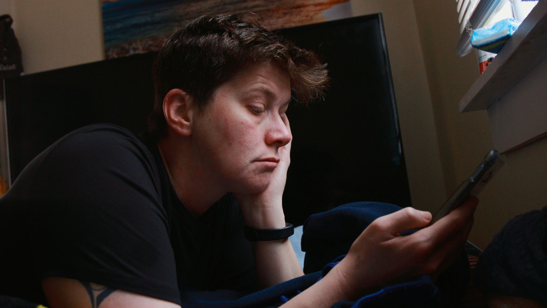 man in black crew neck t-shirt holding black smartphone