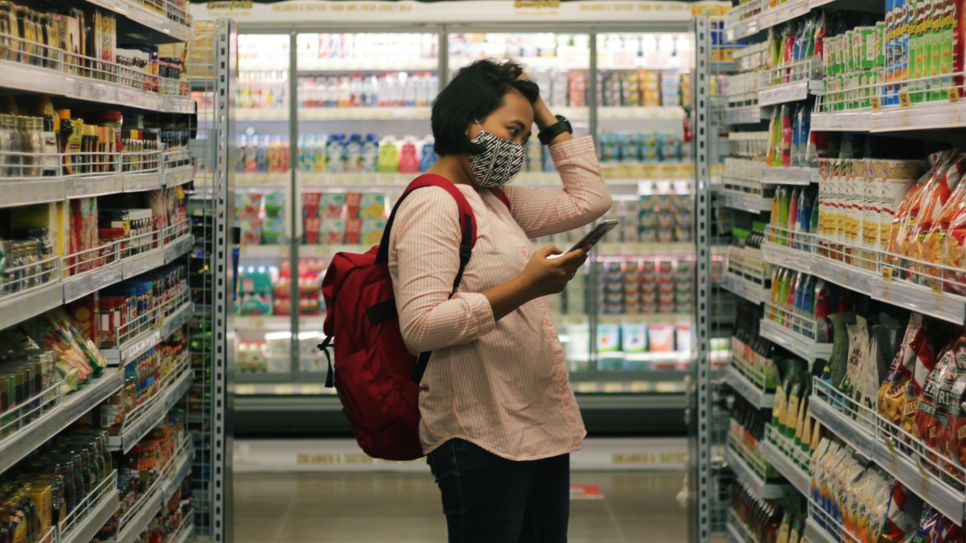 woman in red long sleeve shirt and black pants standing on white floor tiles
