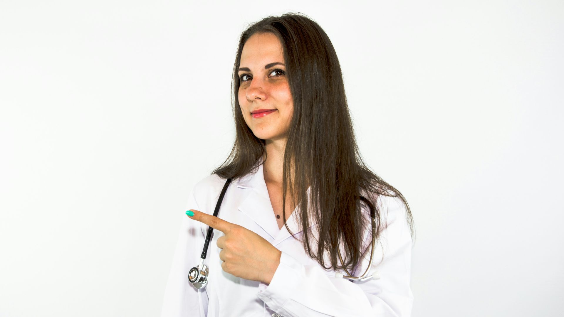 a woman in a white lab coat pointing at something