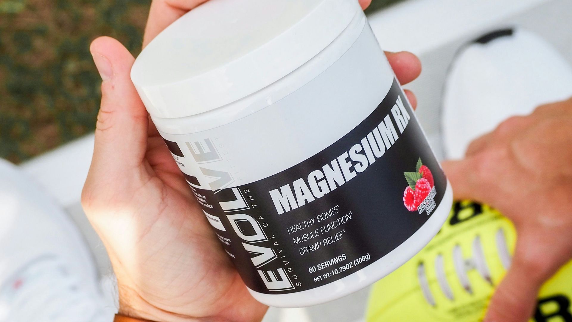 a man holding a jar of vitamin supplement