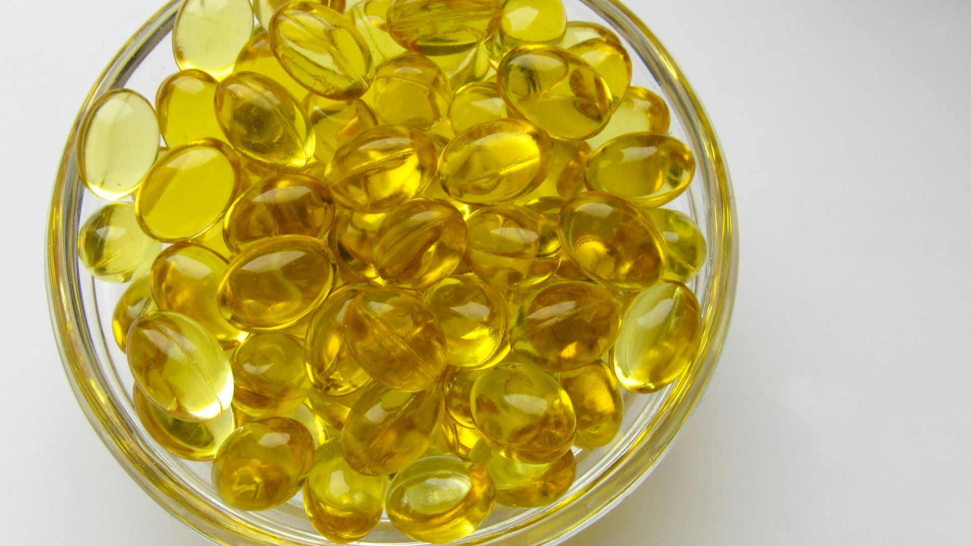 a glass bowl filled with yellow glass beads