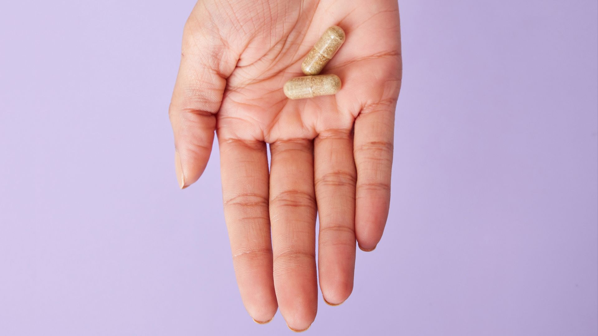 A person holding a pill in their hand