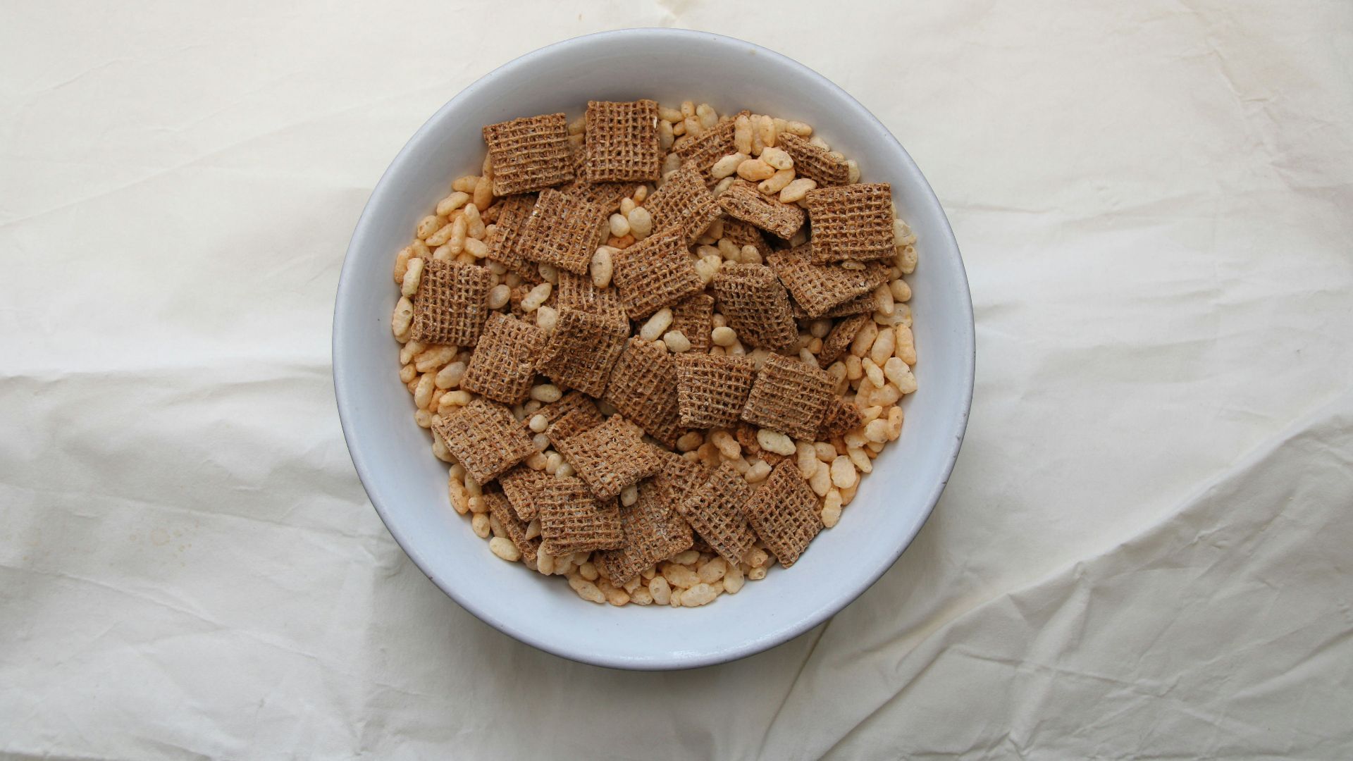 a white bowl filled with cereal on top of a white table