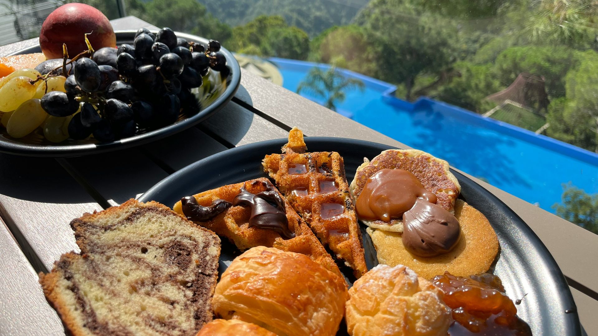 a plate of pastries and a bowl of fruit on a table