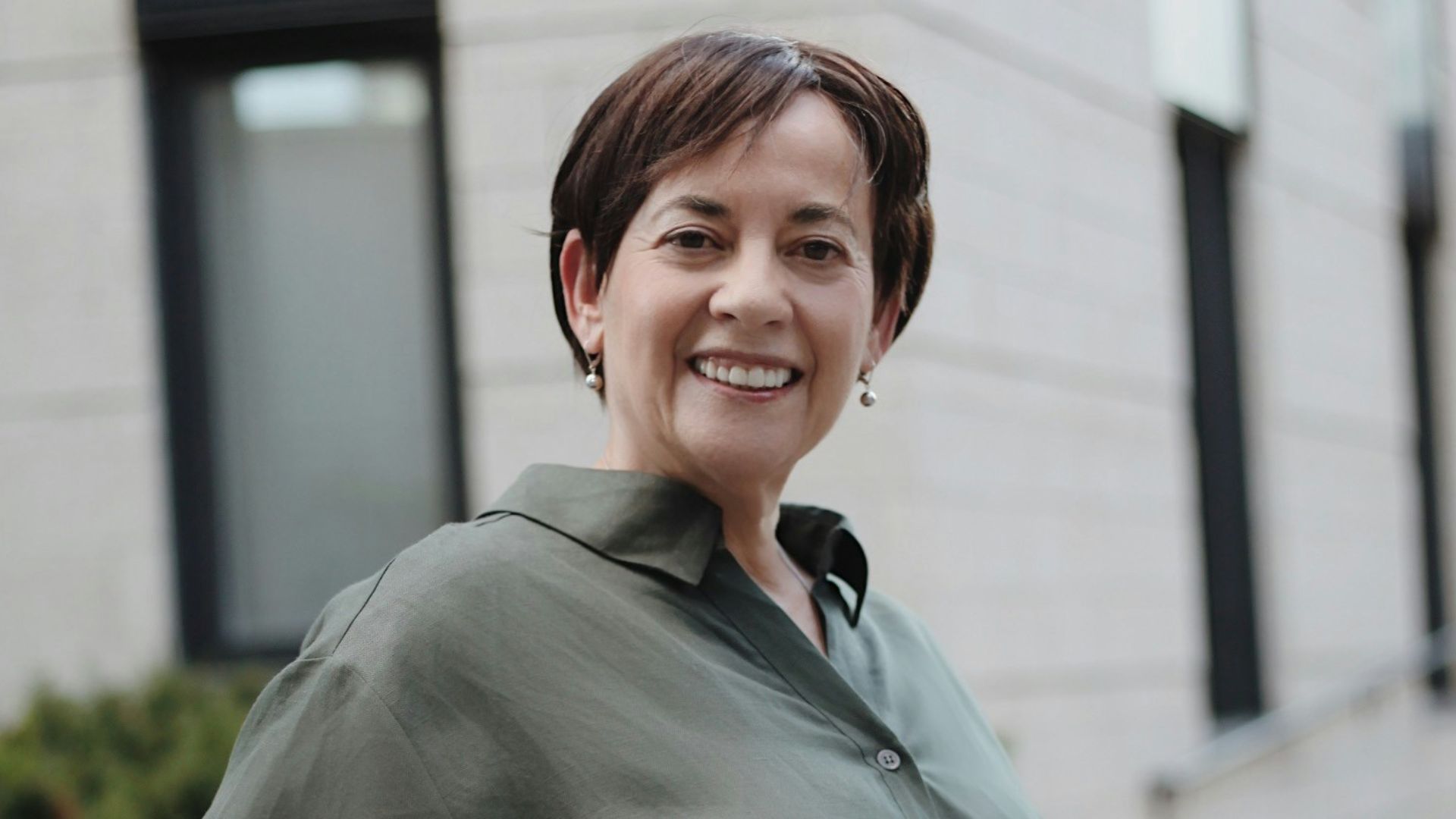 man in green button up t-shirt and white pants standing on road during daytime
