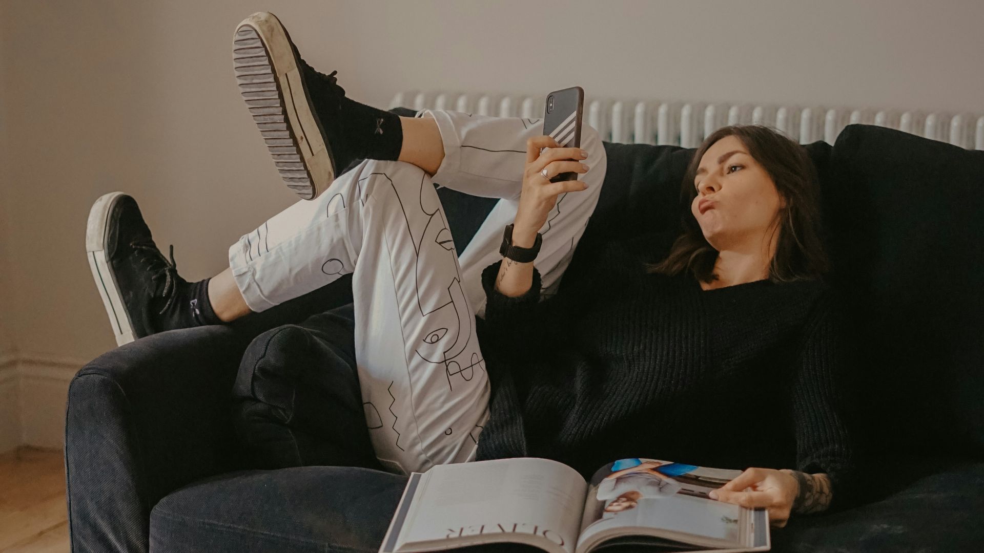 man and woman lying on black sofa