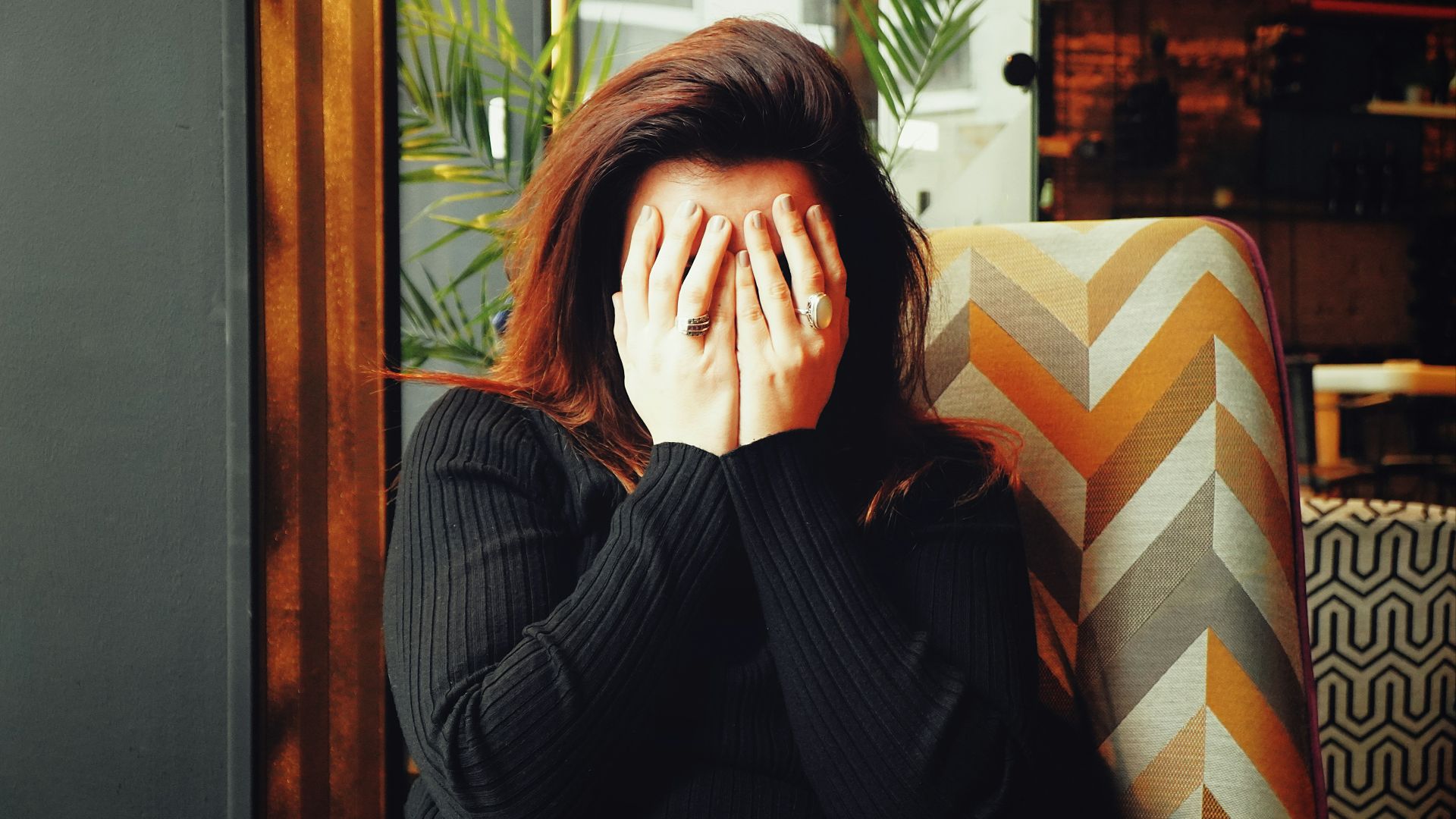 woman in black long sleeve shirt covering her face