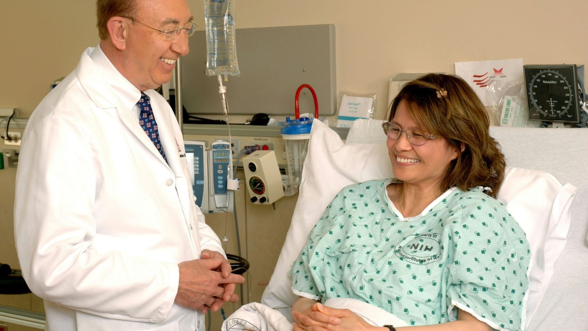 woman in teal scrub suit sitting beside man in white medical scrub suit