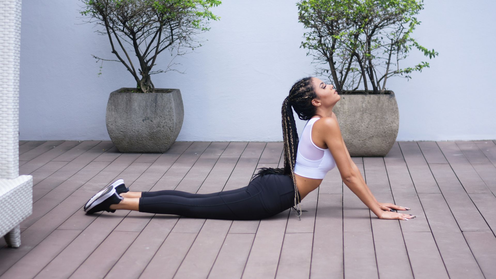 woman in white sports bra and black leggings doing yoga