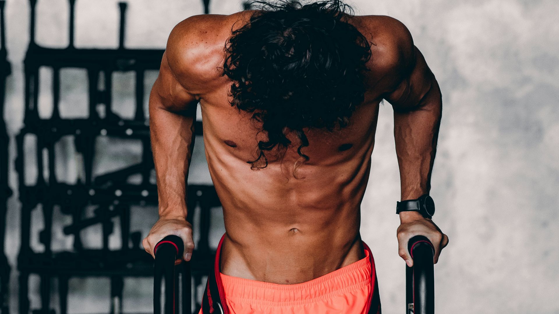 a shirtless man doing a pull up on a bar