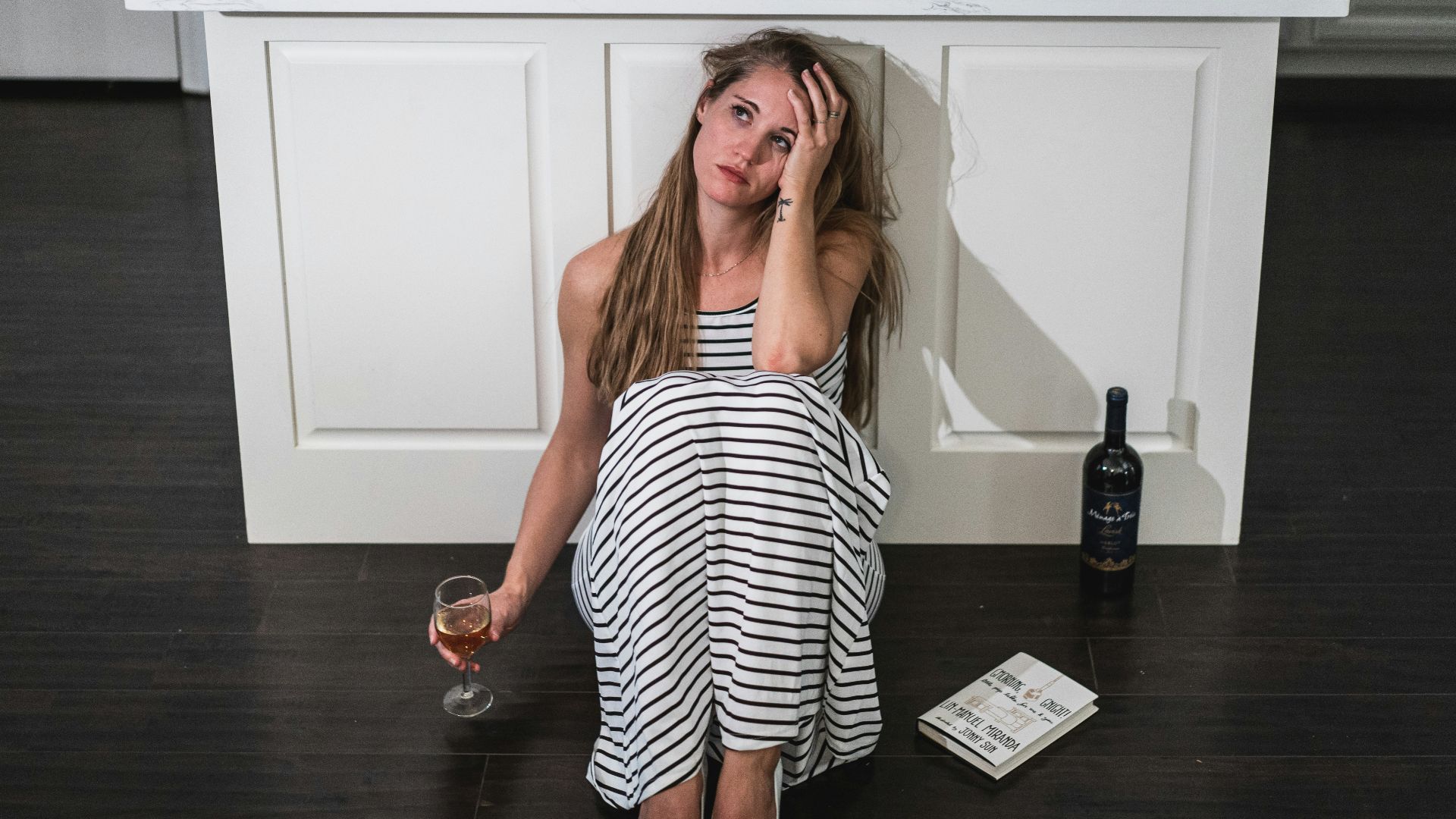 woman in black and white stripe dress holding wine glass