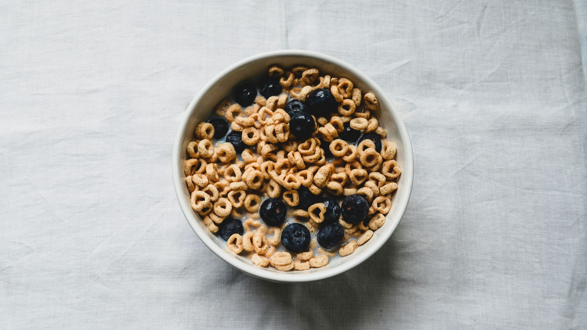 a white bowl filled with cereal and blueberries