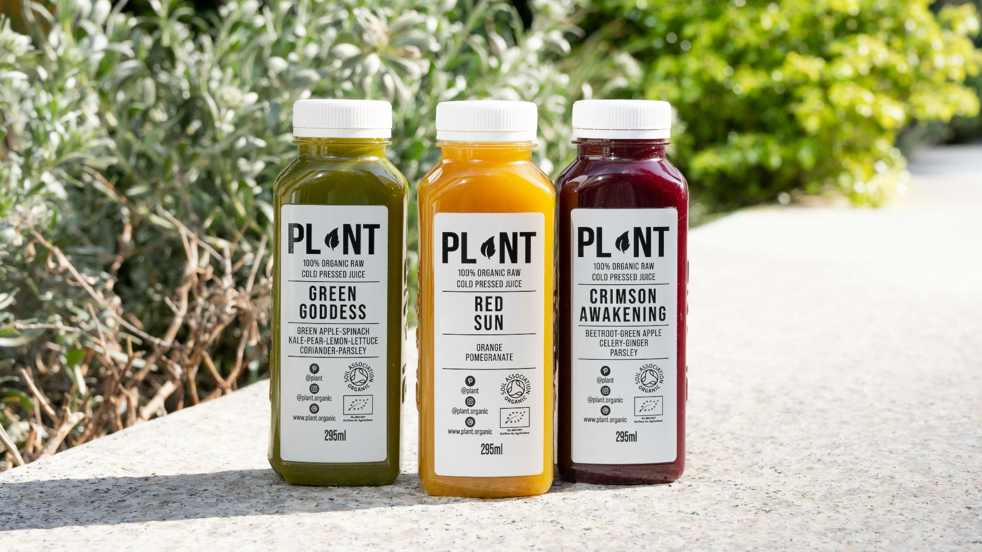 three bottles of juice sitting on a sidewalk