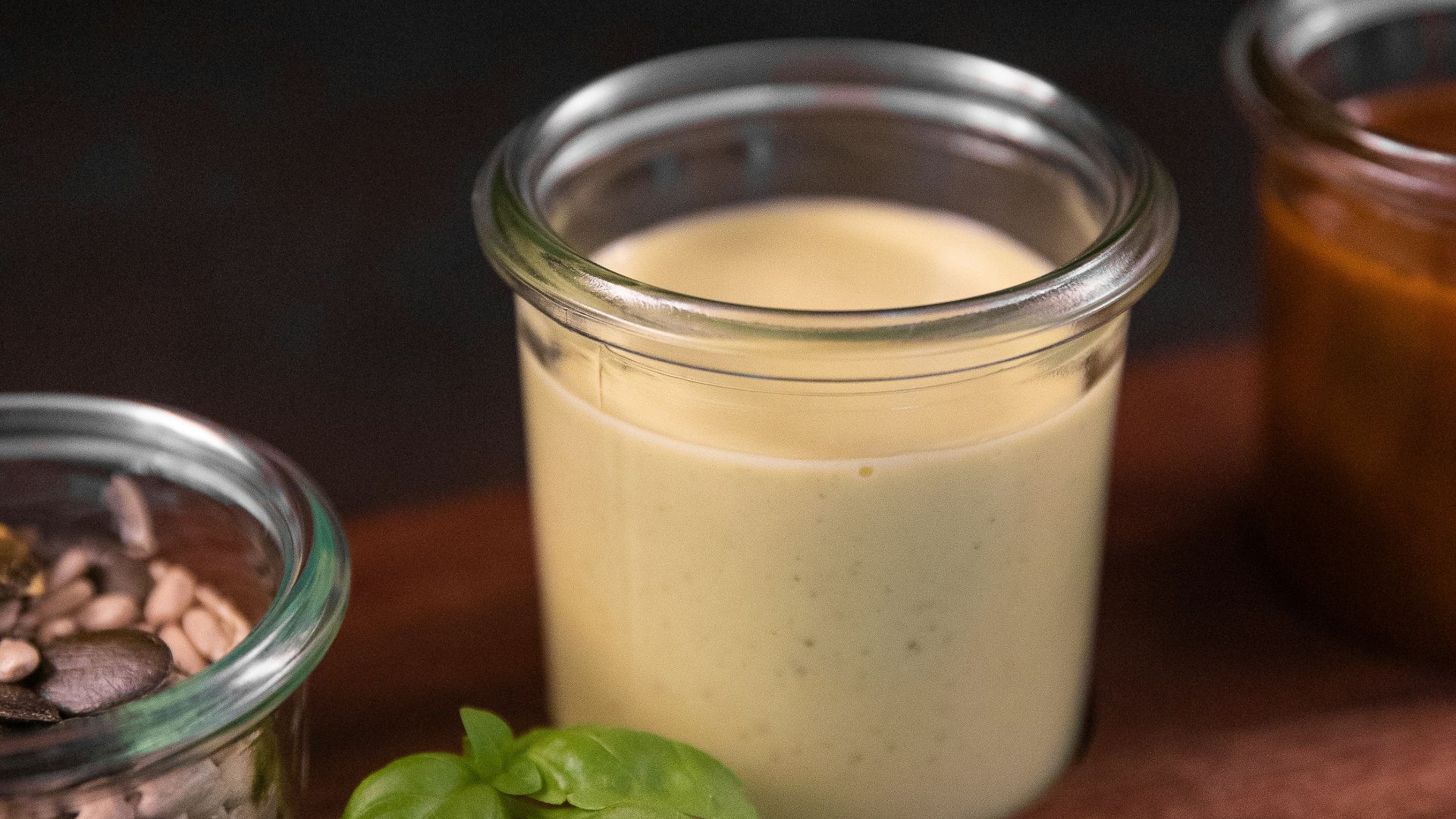 a wooden cutting board topped with jars filled with food
