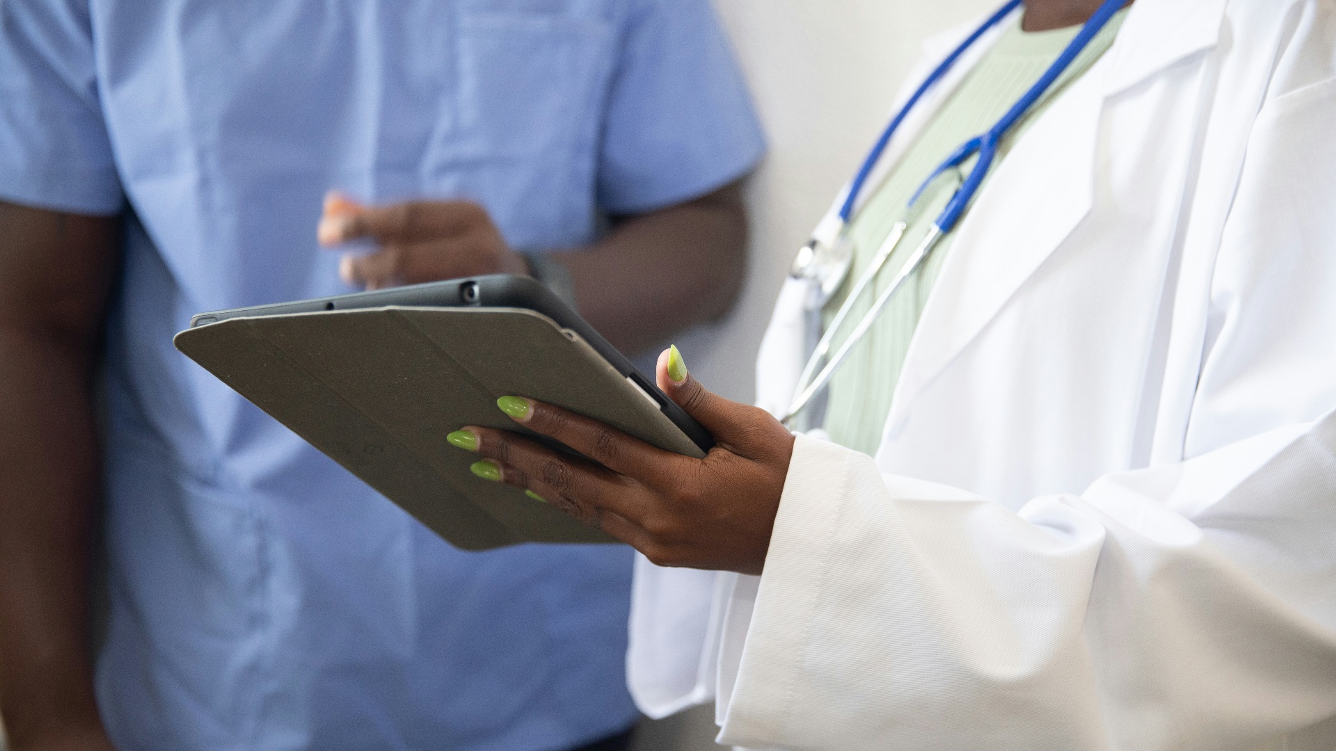 a doctor showing a patient something on the tablet