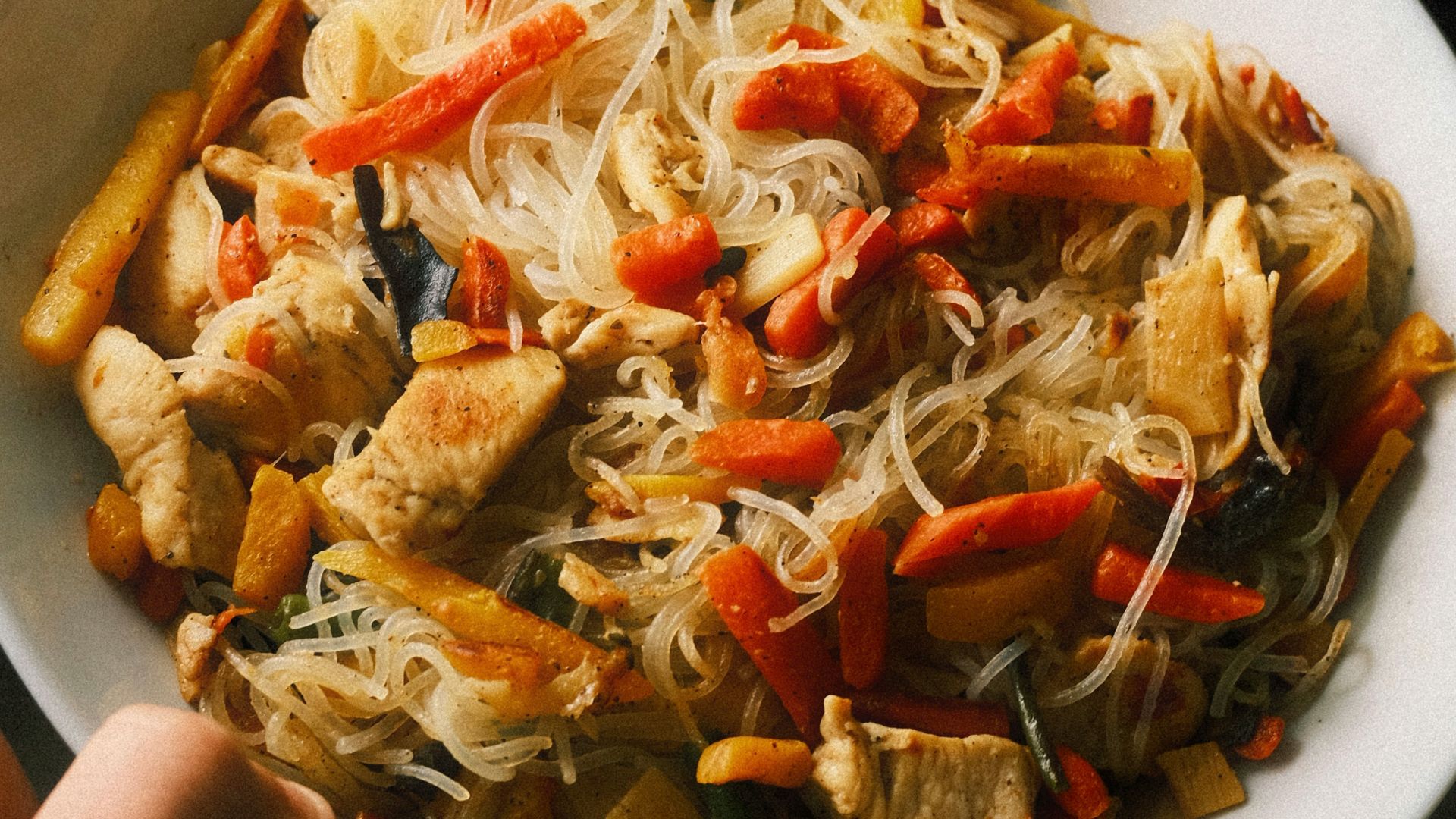 Chicken stir-fry with noodles and vegetables in a bowl