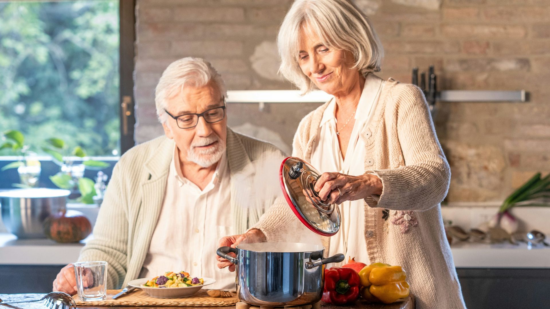 Elderly couple cooking together in a modern kitchen.