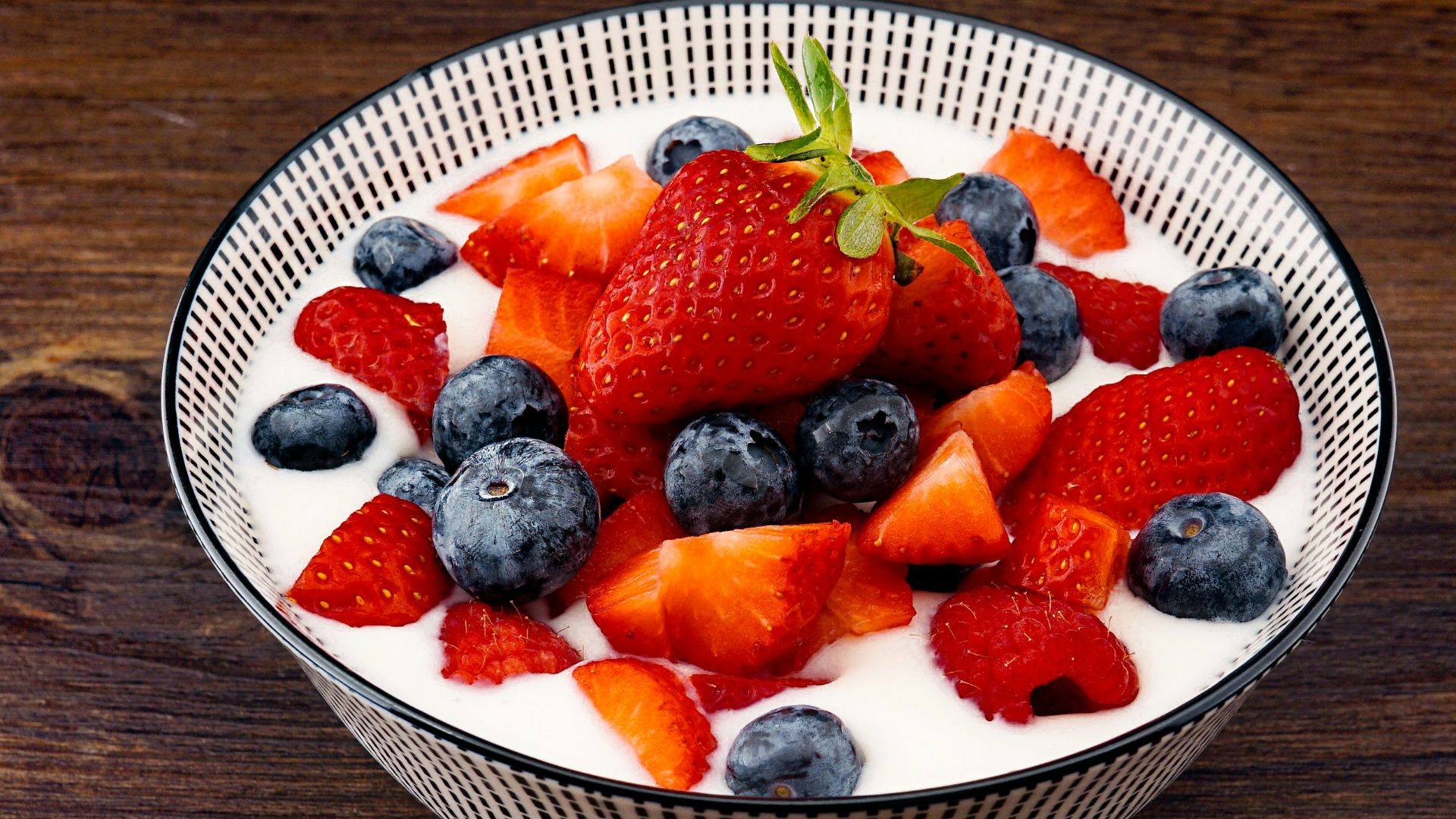 strawberry and blackberries on top of brown table