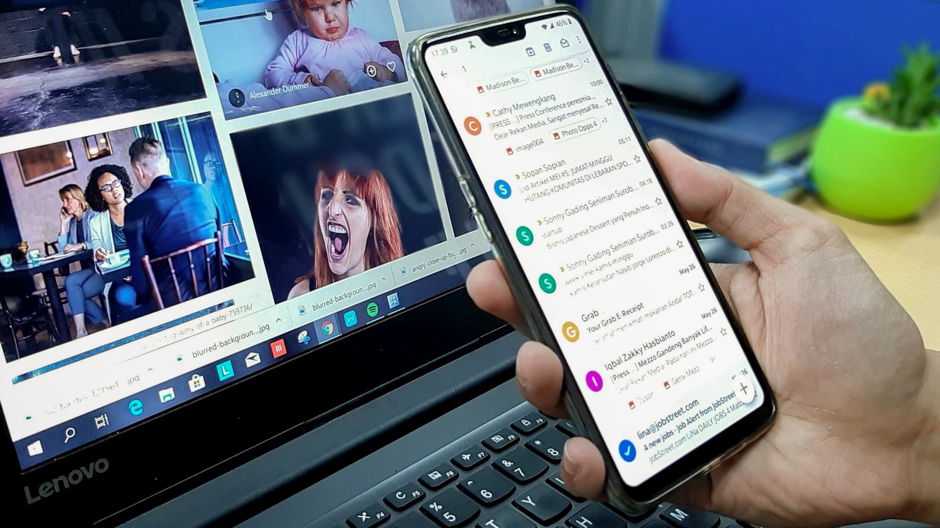 person using smartphone and laptop computer