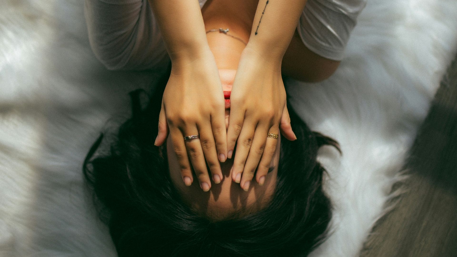a woman holds her hands over her face