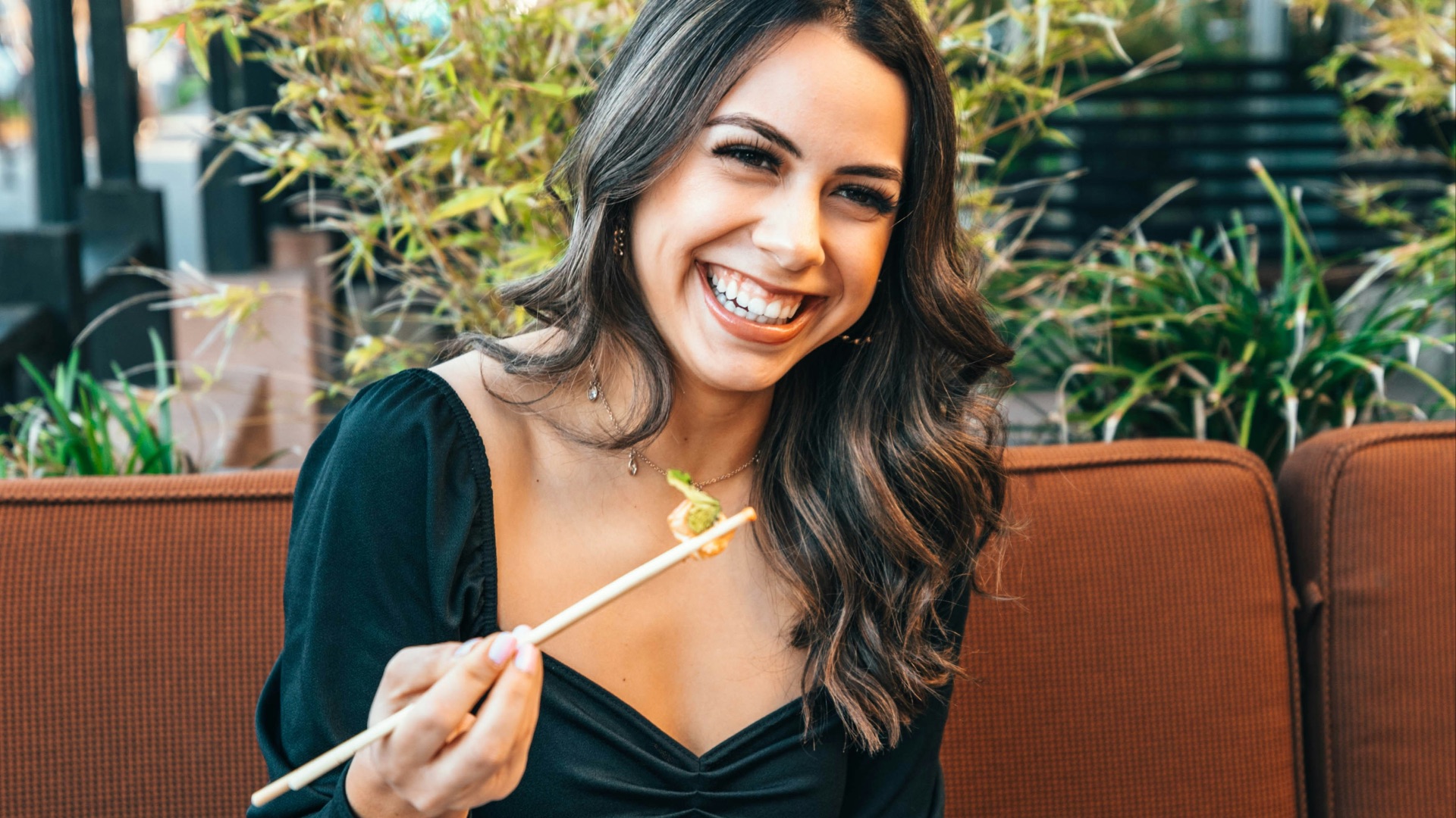 woman in blue long sleeve shirt holding chopsticks