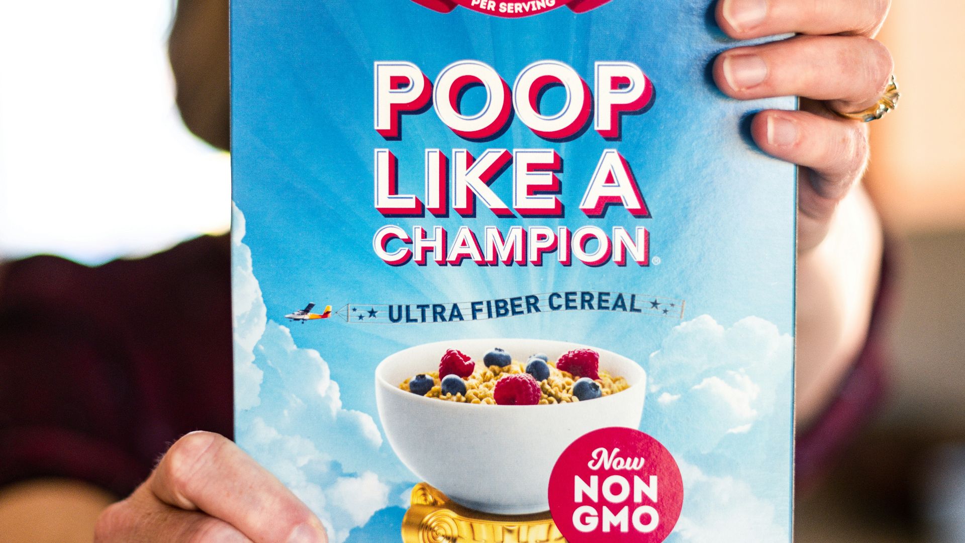 a woman holding up a box of cereal