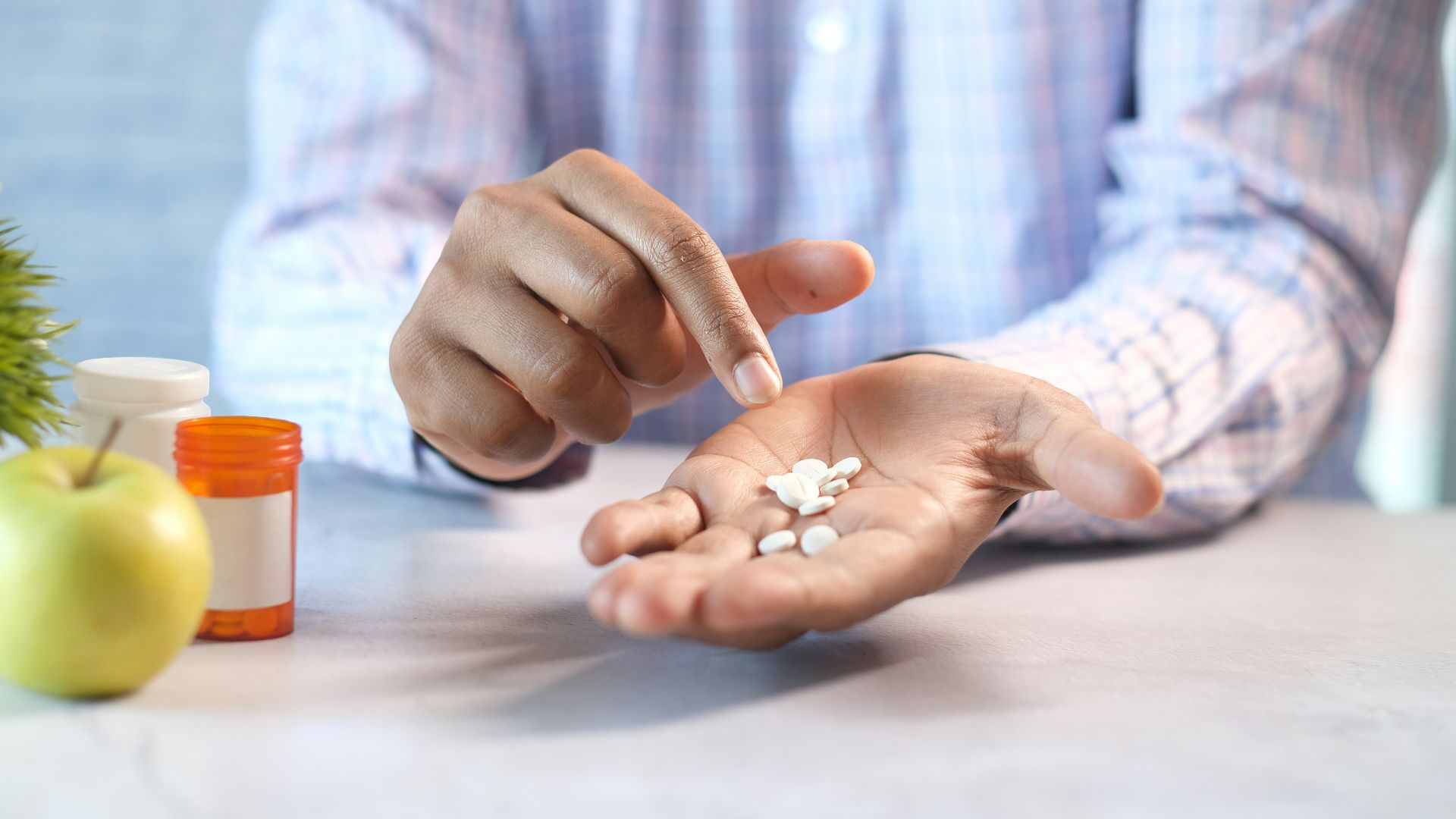 person holding white and orange plastic bottle