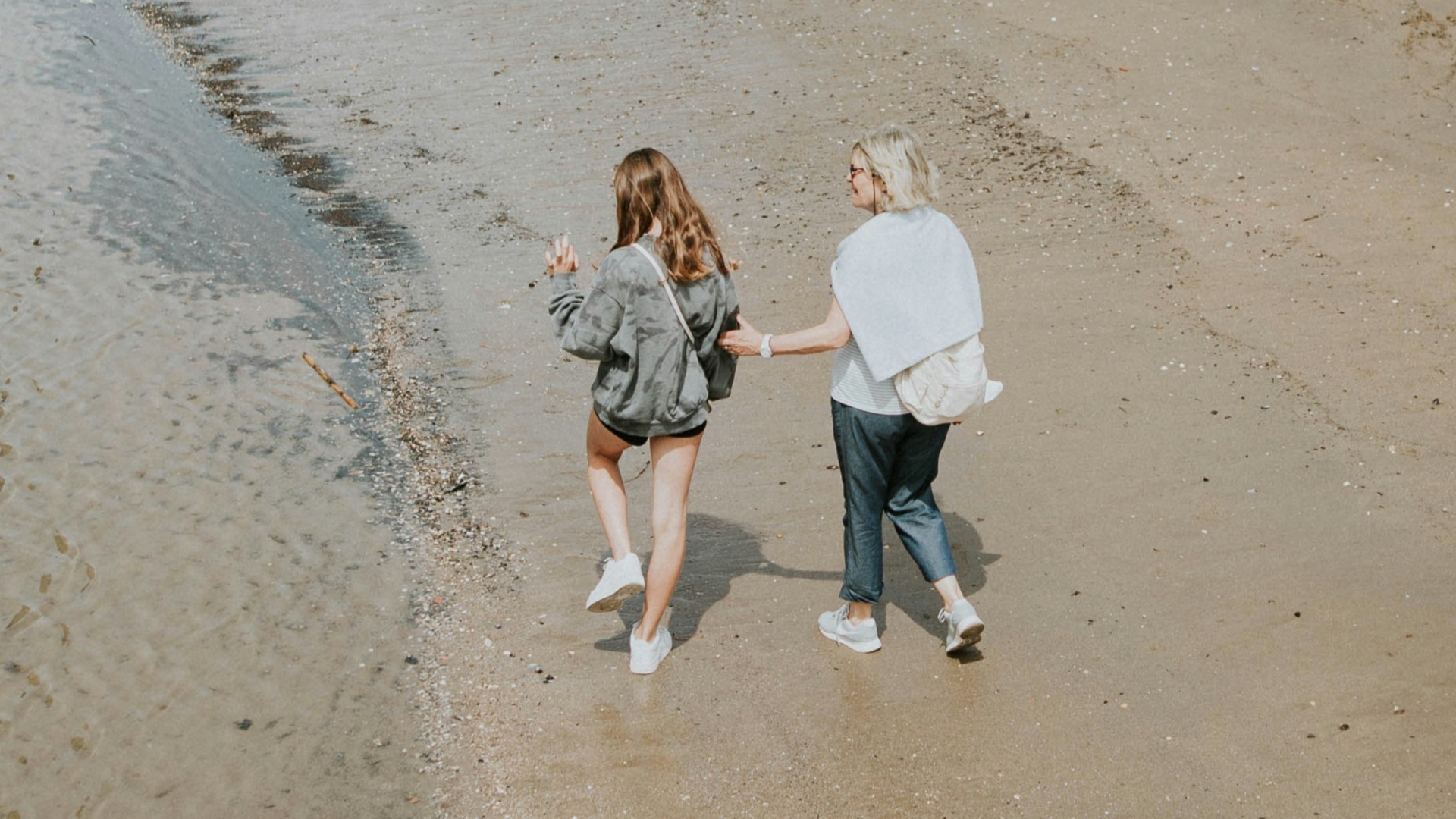 a couple of women walking on a beach