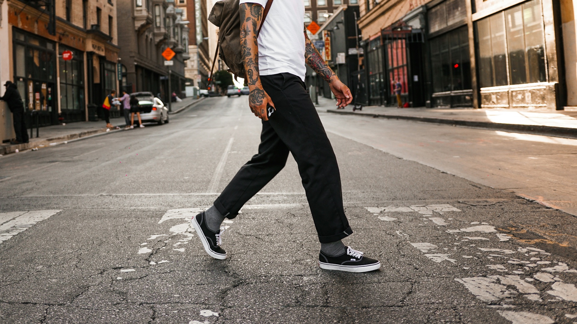 man in white long sleeve shirt and black pants standing on road during daytime