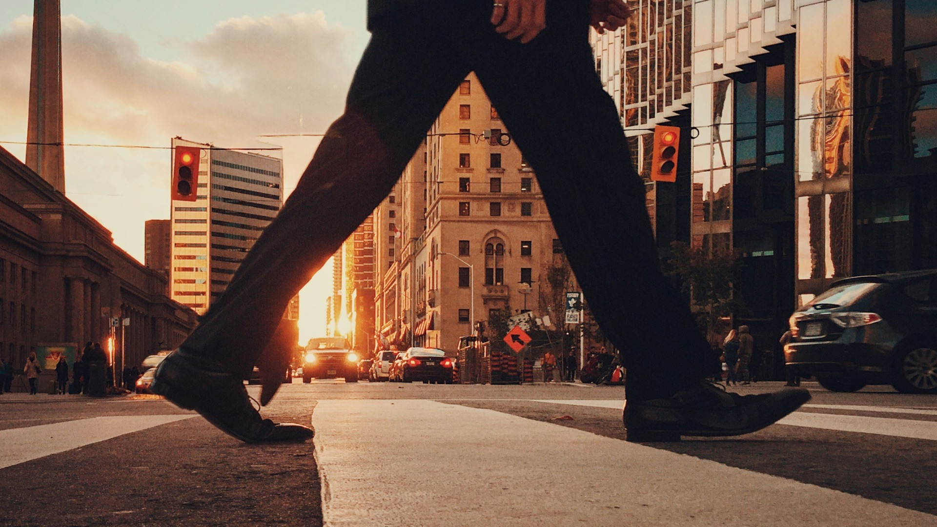 man in dress suit outfit walking in front of building