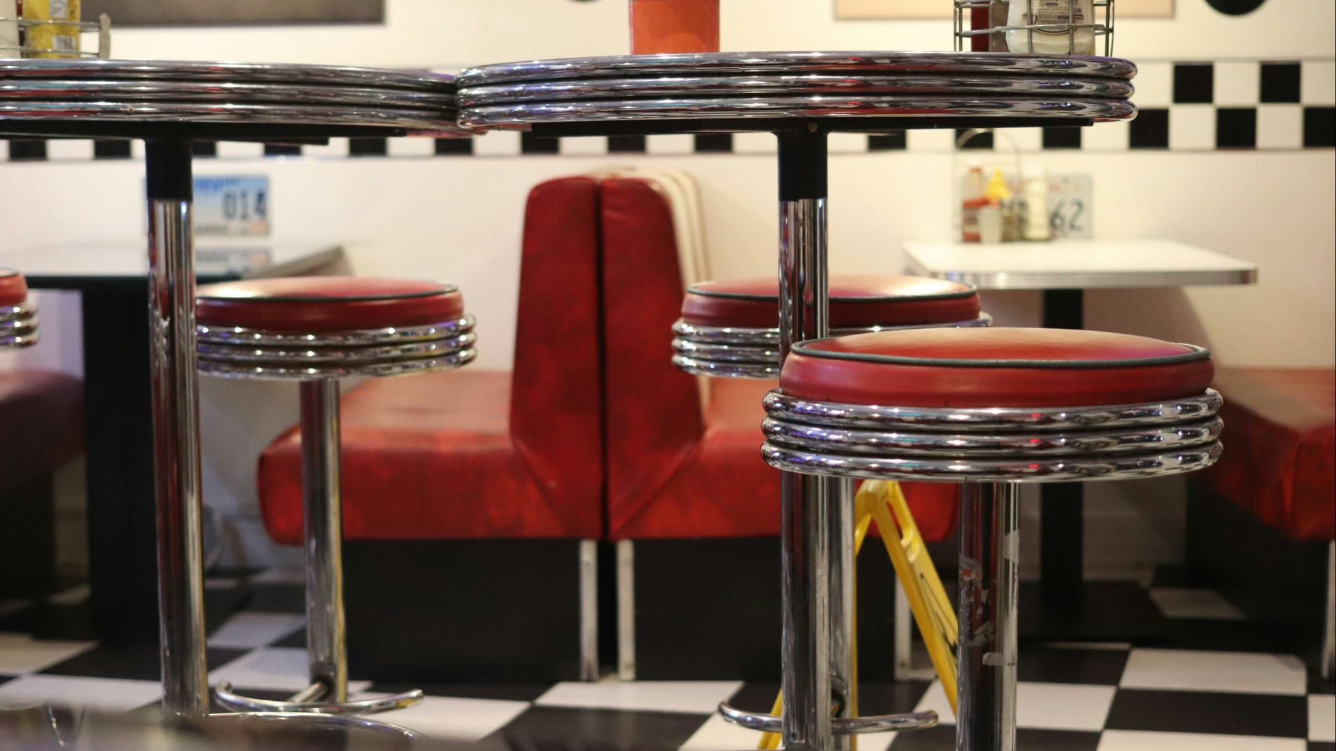Retro diner booths and stools with checkered floor