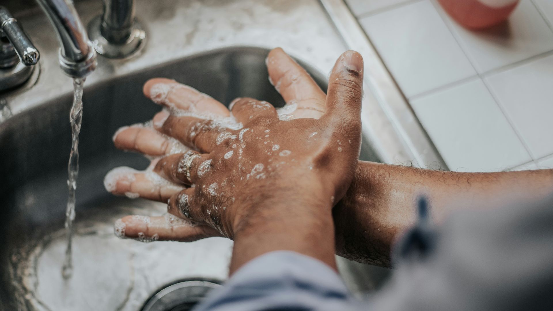 person in white shirt washing hands