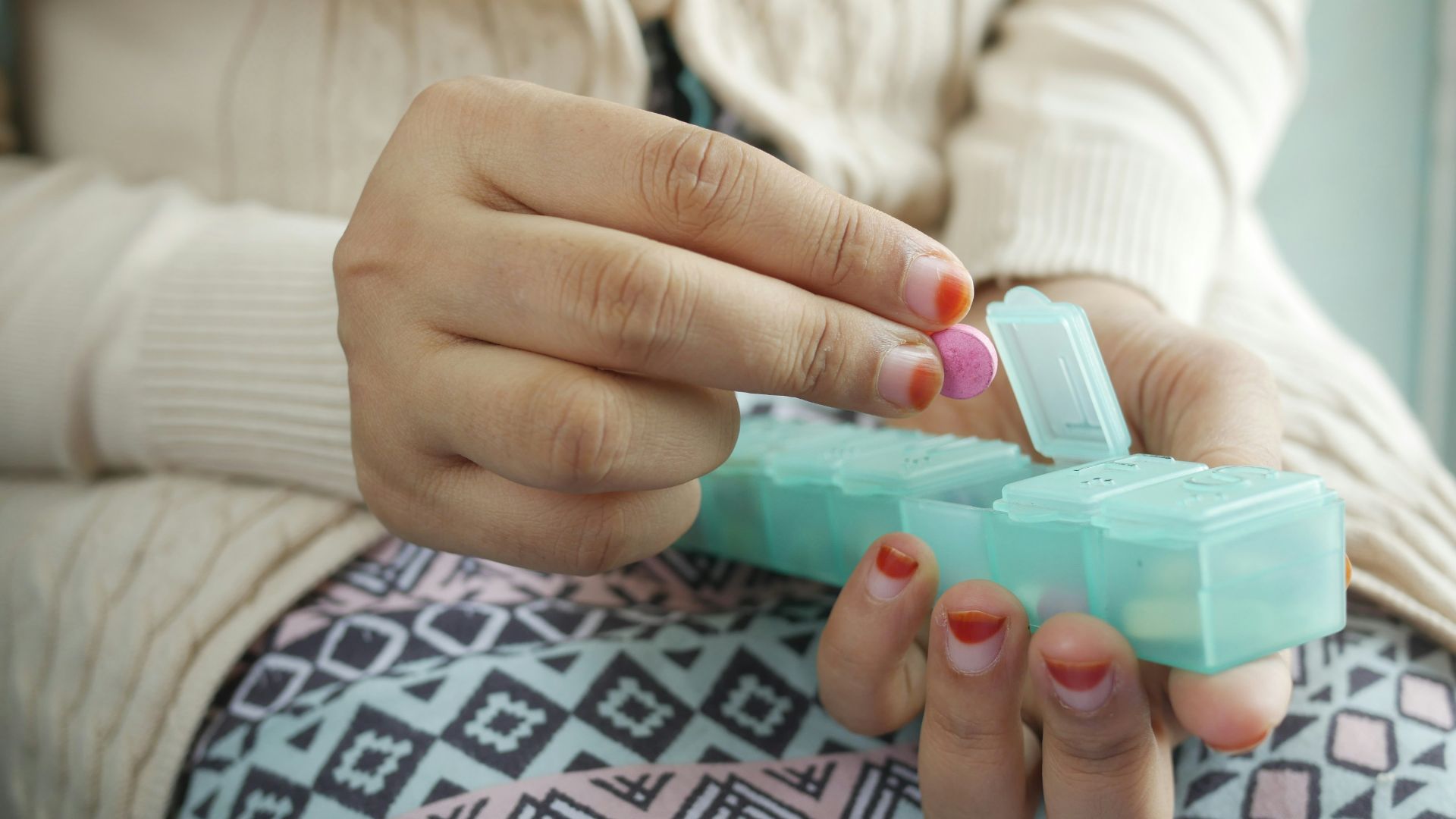 person holding white and green plastic container
