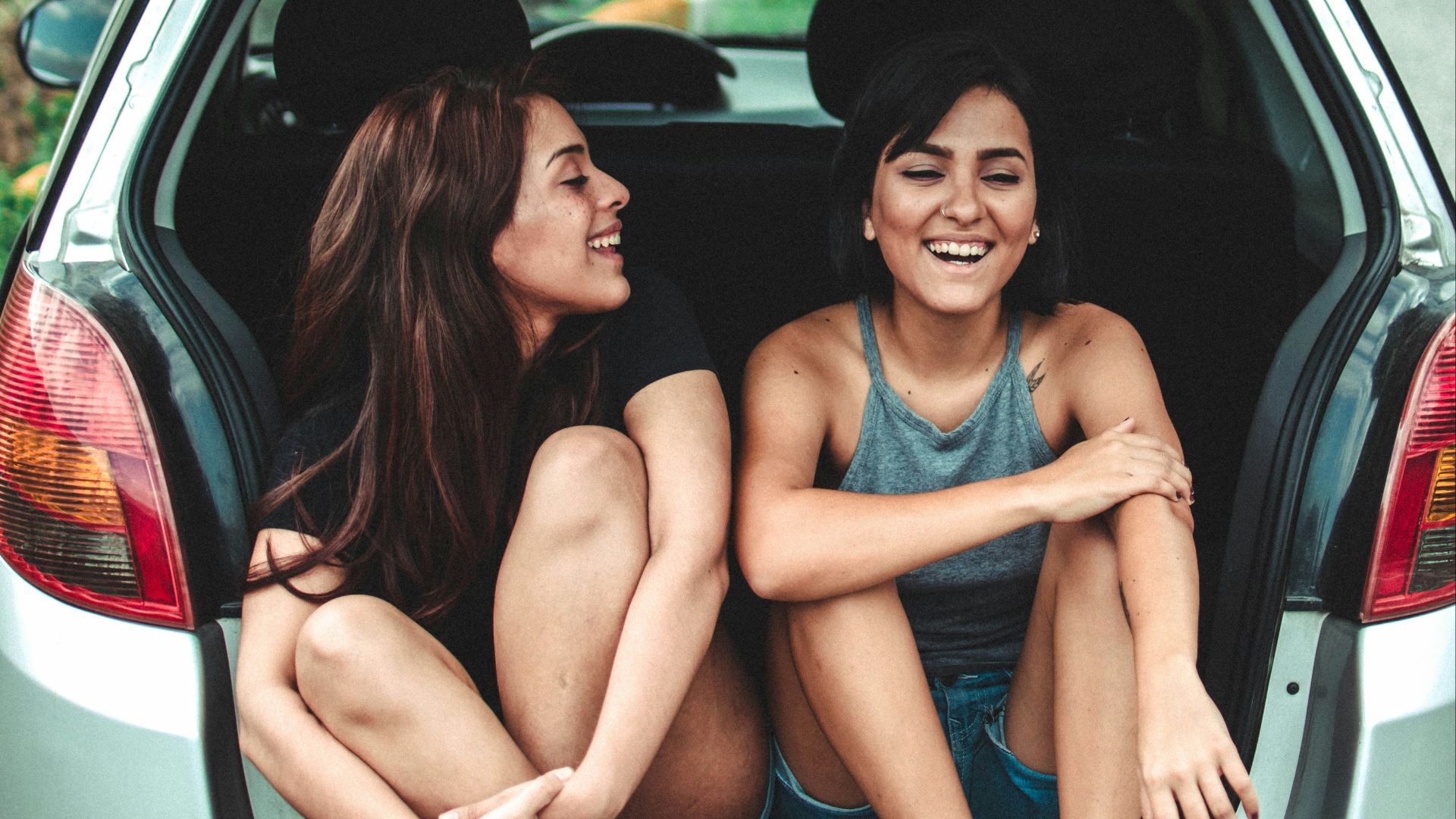two women sitting at the back of the car
