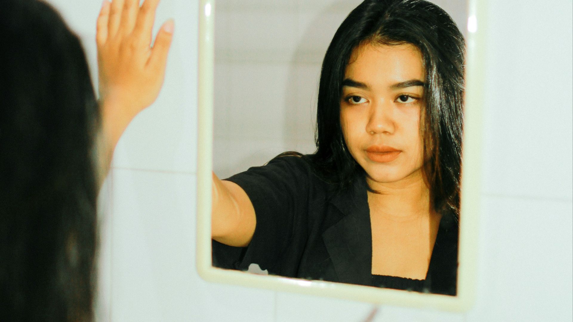 a woman is looking at her reflection in the mirror