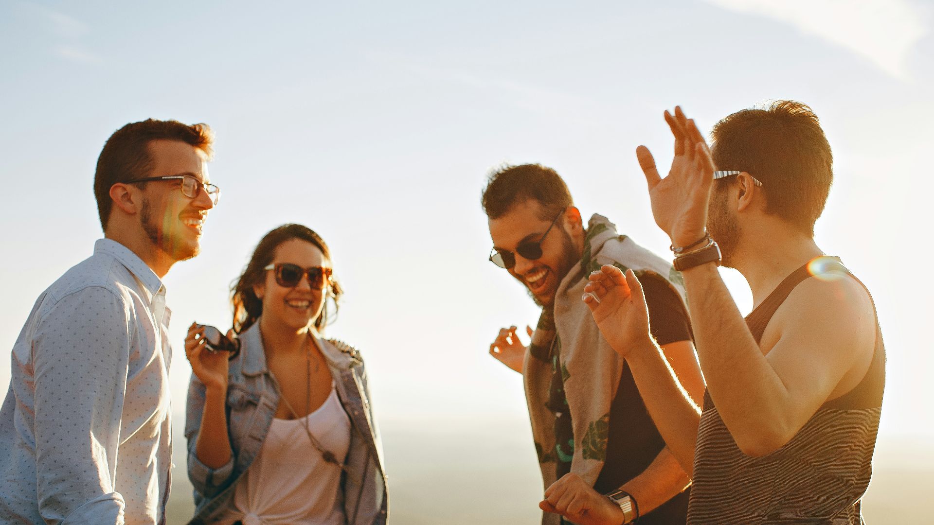 three men and one woman laughing during daytime